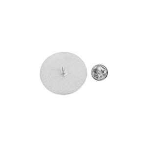Detail of silver round metal brooch back with butterfly clutch and textured finish