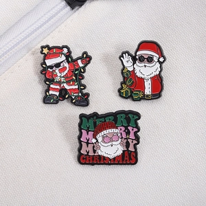 Trois pin's de Noël festifs avec le Père Noël dabbing et lettrage Joyeux Noël artistique