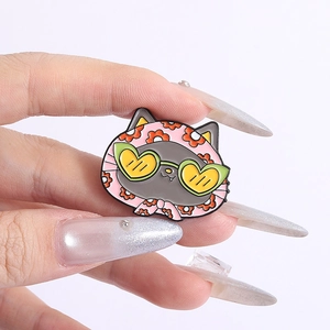 Détail d'une épingle émaillée chat mignon avec foulard rose à fleurs et lunettes de soleil