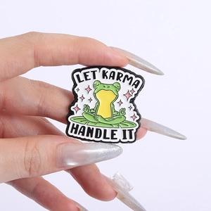 Funny meditating frog enamel pin with Let Karma Handle It text on a lily pad