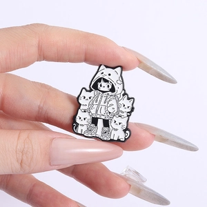 Pin's en émail noir et blanc représentant une fille en sweat à oreilles de chat et chats