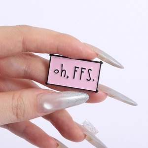 Detailed close-up of a pink enamel pin featuring the hand-written text oh, FFS.