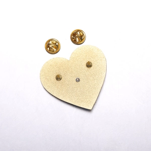 Dettaglio del retro della spilla a cuore smaltata dorata con doppia chiusura a farfalla