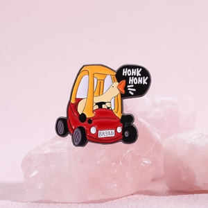 Cute enamel pin featuring a white goose driving a red and yellow toy car with Honk text