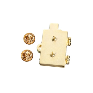 Detailed view of the gold alloy luggage brooch with dual pins and butterfly clutches