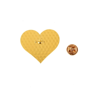 Détail du dos de broche cœur doré avec texture nid d'abeille et fermoir papillon