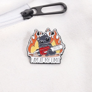 Detail of funny chainsaw black cat enamel pin with I Am At My Limit text on white canvas