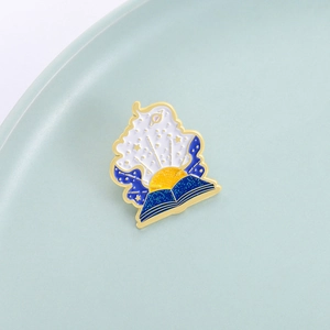 Starry sky magic book enamel brooch with gold stars and planet designs on blue book