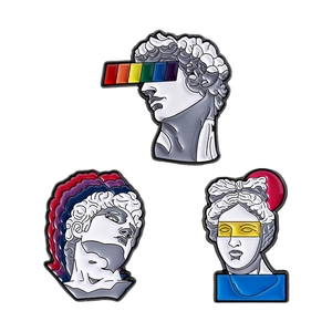 Three enamel pins featuring classical sculptures with rainbow pop art elements on white