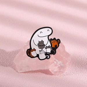 Close-up of a cartoon metal pin showing a minimalist figure holding four colorful cats