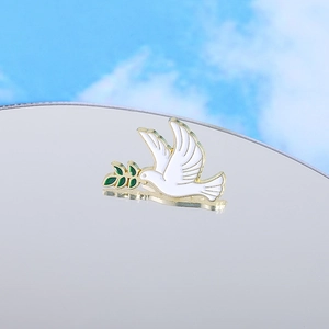 Broche colombe de la paix en émail blanc avec rameau d'olivier et métal doré