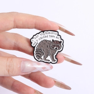 Gros plan d'un pin's en émail de râteau brun avec des détails de texte de citation drôle