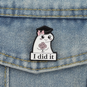Close-up of ghost enamel pin with graduation cap and flowers on denim jacket