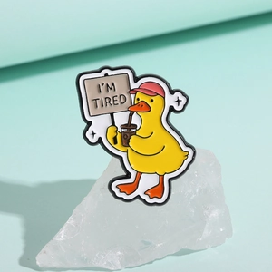Detail der süßen gelben Enten-Emaille-Anstecknadel mit I'M TIRED Schild auf weißem Stein