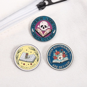 Three round enamel pins set with Horror Addicts Book Club theme on white canvas bag