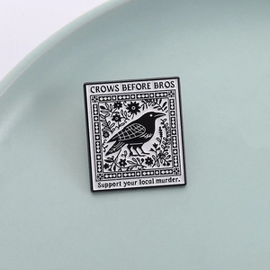 Dunkler rechteckiger Emaille-Raben-Anstecker mit Crows Before Bros Spruch auf Keramik