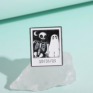 Macro view of a Halloween Polaroid pin with skull, ghost, and 10/31/25 date engraving