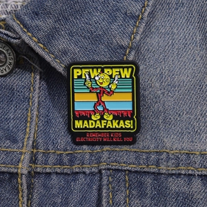Détail d'un pin's émaillé rétro avec texte 'Pew Pew' sur une veste en jean bleue