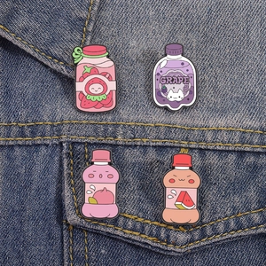 Cute fruit soda bottle enamel pins featuring strawberry grape peach and watermelon designs