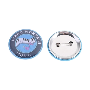 Detailed front and back view of a blue piano music theme tinplate badge with safety pin