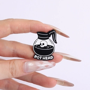 Close-up of a creative enamel coffee pot pin featuring a skull design and Pot Head text