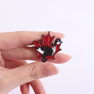 Detail of enamel Canada Goose pin with Elbows Up text on a red maple leaf background