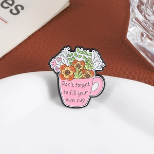 Detail of pink floral enamel pin featuring Don't forget to fill your own cup text