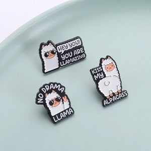 Three cute cartoon llama enamel pins with humorous text on a turquoise tray