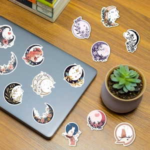Detail of floral and moon stickers on laptop and wooden desk for planner decoration