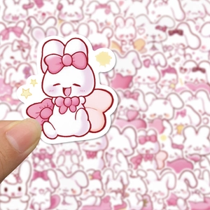 Detailed view of hand holding a cute pink rabbit sticker with star accents for decoration