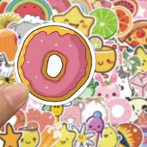 Gros plan d'une main tenant un autocollant donut parmi des décalcomanies VSCO étanches