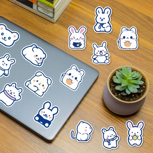 Close-up of cute blue-lined animal stickers on laptop and desk with plants