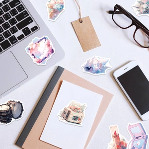 Flat lay of dreamlike pastel stickers including camera and shell on a desk with laptop
