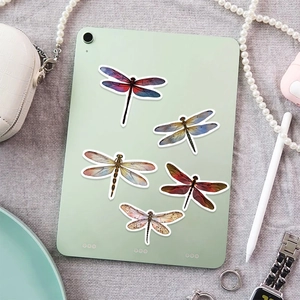 Detailed view of realistic dragonfly stickers on a tablet with elegant accessories