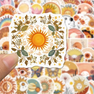 Close-up of a hand holding a sun sticker from a nature-themed bohemian decal collection