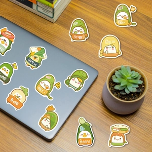 Close-up of cute cartoon food stickers applied to a silver laptop on a wooden desk