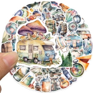 Gros plan d'une main tenant un autocollant aquarelle de camping-car du kit de voyage