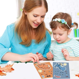Detail of children making DIY dinosaur stickers with colorful cartoon facial features