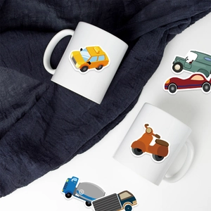 Detail of colorful cartoon vehicle stickers applied on a white ceramic coffee mug