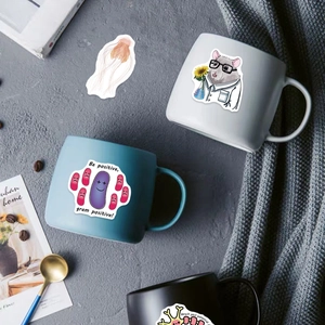 Close-up of biology laboratory stickers with neuron and hamster patterns on coffee mugs