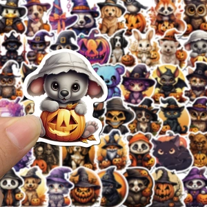 Close-up of a hand holding a cute Halloween koala sticker among diverse animal decals