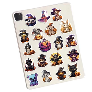 Close-up of cute Halloween animal stickers on tablet back with pumpkin and witch hats