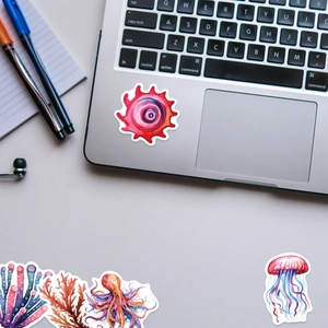 Detailed view of watercolor sea creature stickers on a laptop surface with octopus and coral