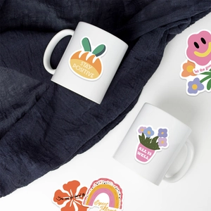 Détail d'autocollants roses motivants avec des dessins mignons sur un mug blanc