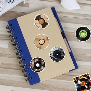 Detailed view of creative vinyl record stickers on a blue notebook cover over wood surface