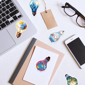 Flat lay of creative bulb stickers on laptop and desk with stationery and glasses