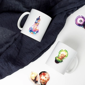 Close-up of waterproof light bulb stickers on mugs showing ocean and cat illustrations