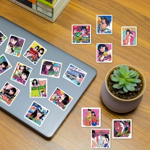 Gros plan d'autocollants rétro anime City Pop sur un ordinateur portable argenté