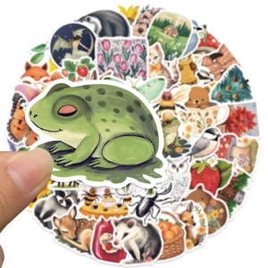 Close-up of a frog sticker being held over a pile of mystical forest animal stickers