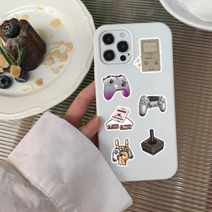 Close-up of white iPhone case with vintage retro game controller stickers on a table